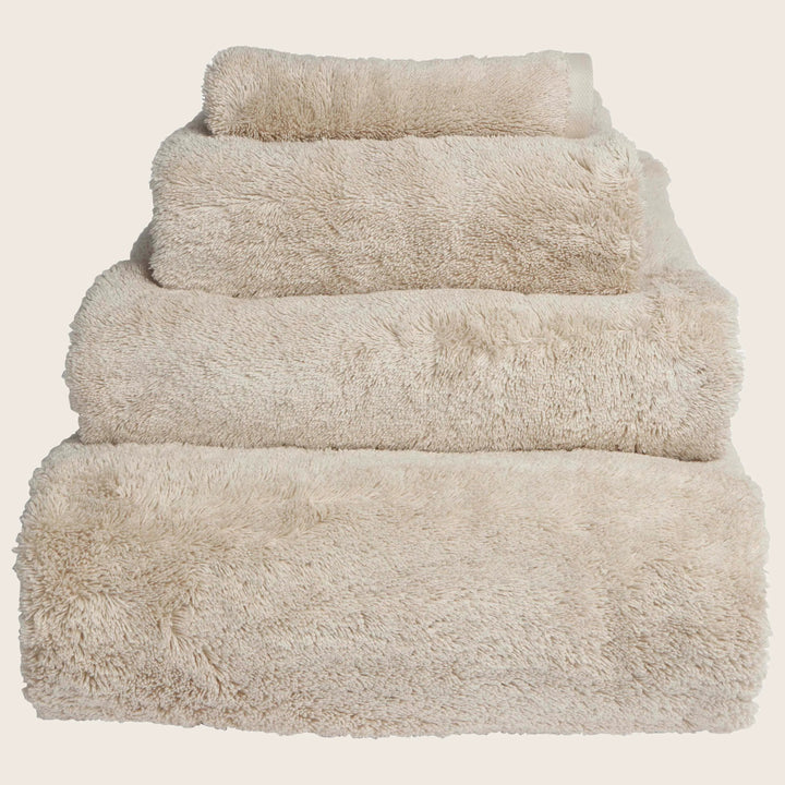 Neatly stacked beige towels in descending order of size.