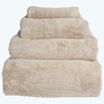 Neatly stacked beige towels in descending order of size.