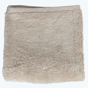 Neatly stacked beige towels in descending order of size. - hover