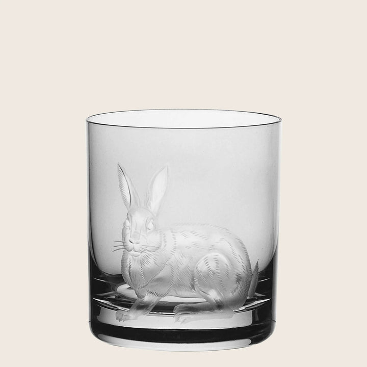 Clear glass tumbler with etched rabbit design on white background.