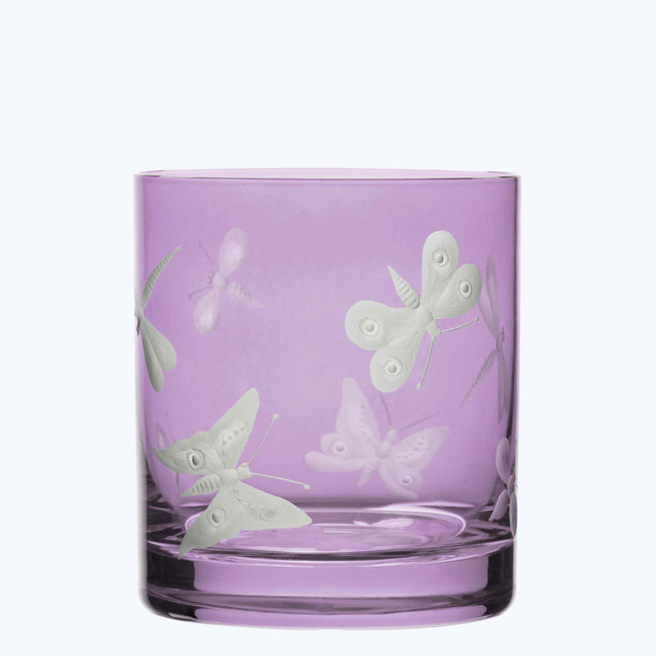 Empty cylindrical glass with purple hue and butterfly designs engraved.