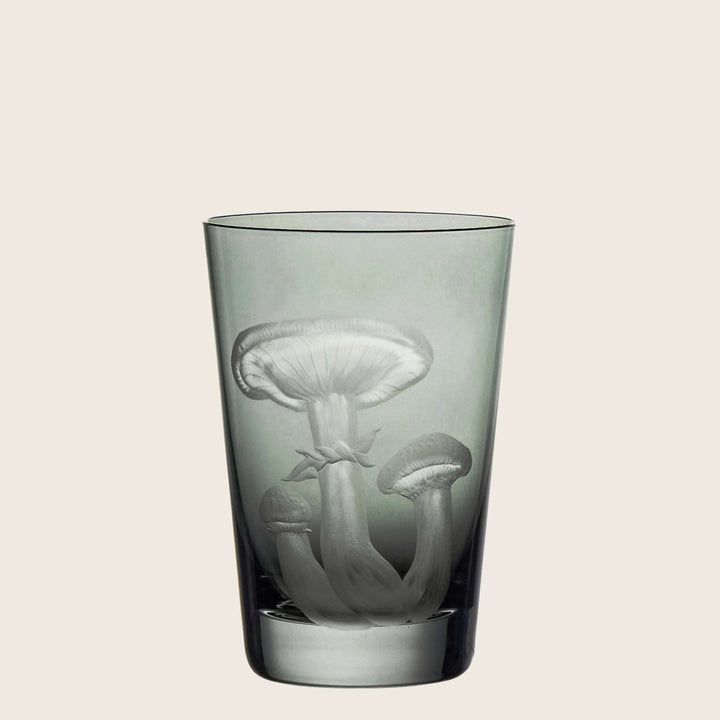 Glass tumbler featuring detailed mushroom design, greyish translucent with thick base.