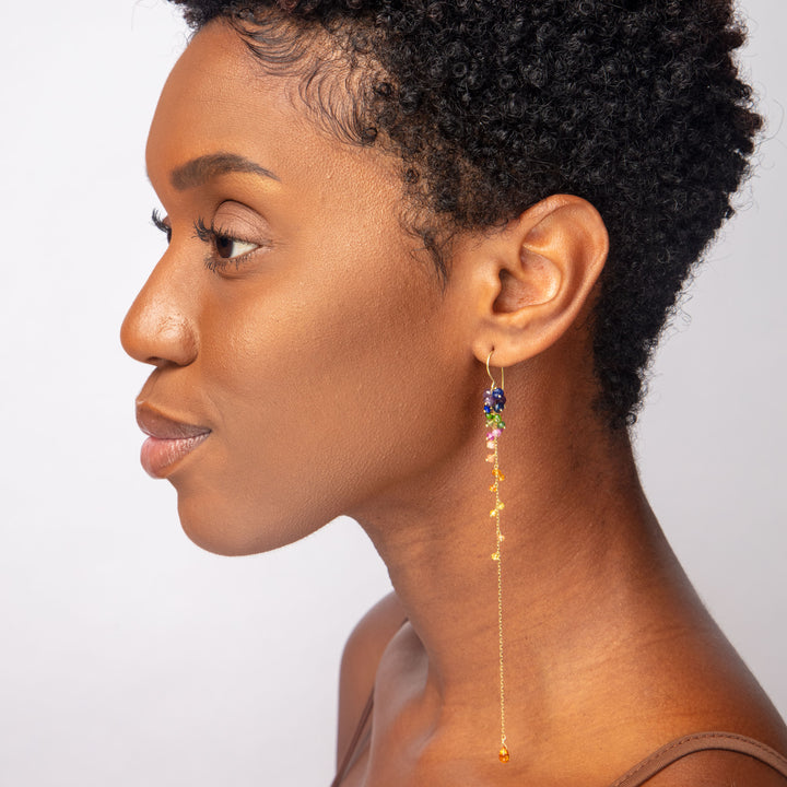 Close-up of stylish woman with dark skin, colorful earring detail.