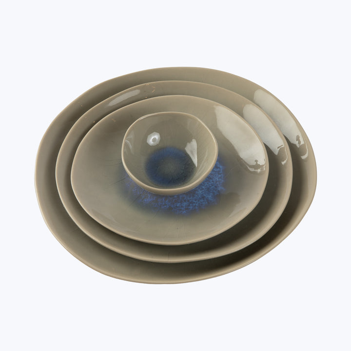 Stack of ceramic dishes in neutral tones with blue design.
