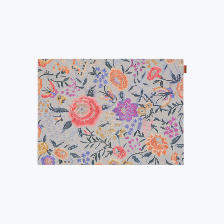Vibrant floral fabric with pink, orange, and purple flowers.