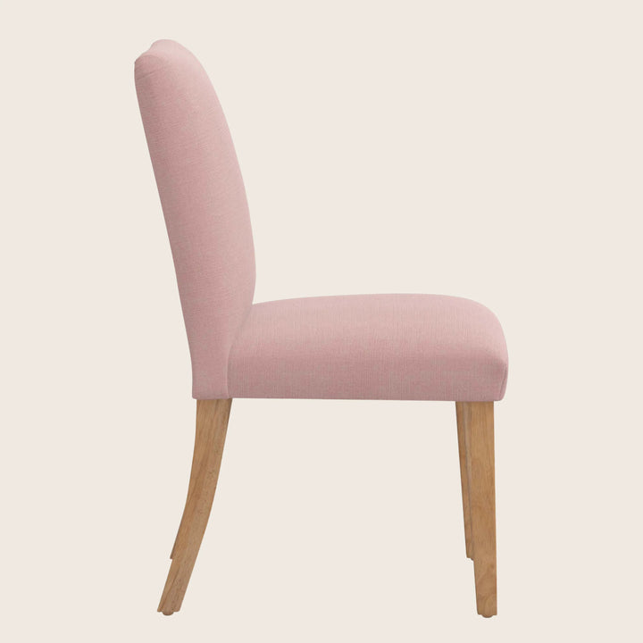 Pink upholstered dining chair with elegant design and wooden legs.