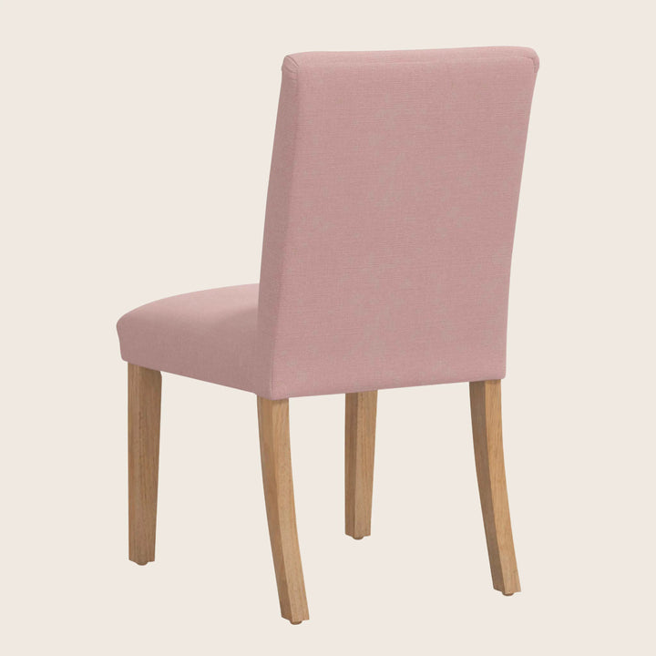 Modern pink upholstered dining chair with wooden legs for comfort.
