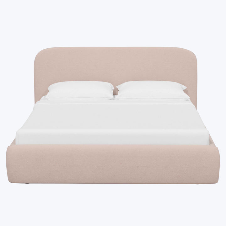 Modern-style bed with upholstered headboard, blush base, and white bedding.