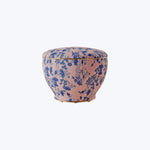Traditional Asian-inspired floral patterned bowl on pinkish-beige background.