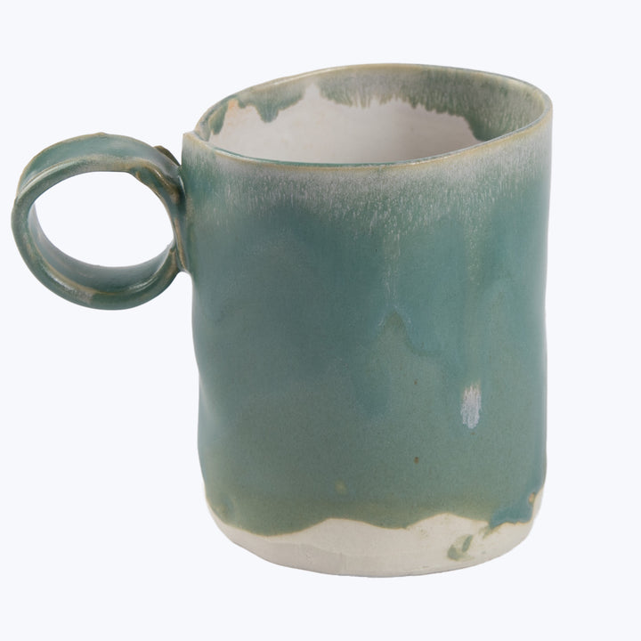 Handcrafted green ceramic mug with slight imperfections, neutral background.
