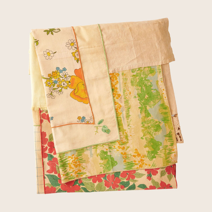 Neatly folded vintage textiles with floral patterns in various colors.