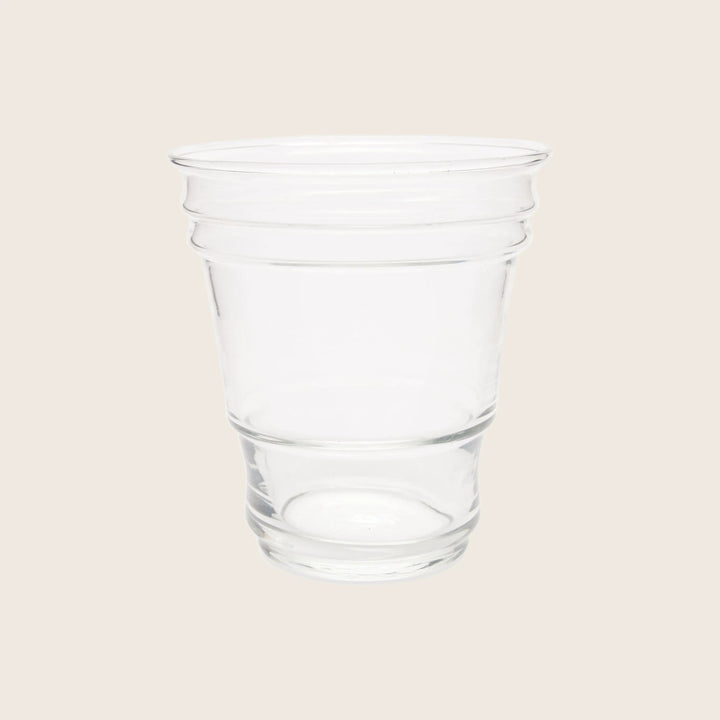 Transparent plastic cup on white background, empty with tapered design.