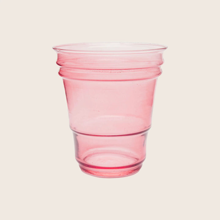 Single pink plastic cup with ribbed design on white background.