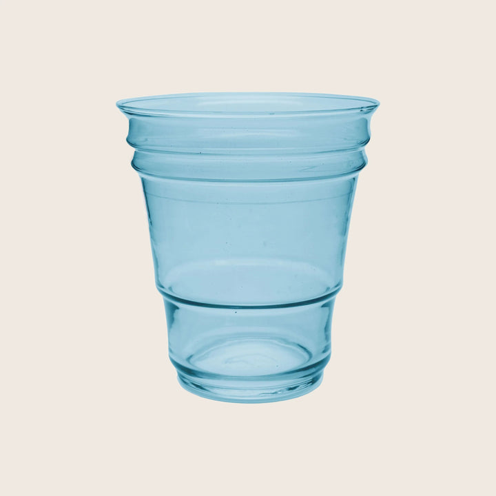 Translucent blue plastic cup with circular ridges on white background.