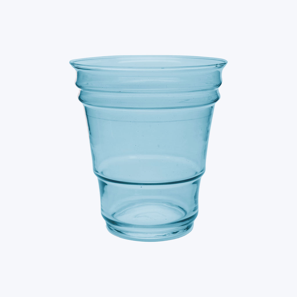 Translucent blue plastic cup with circular ridges on white background.