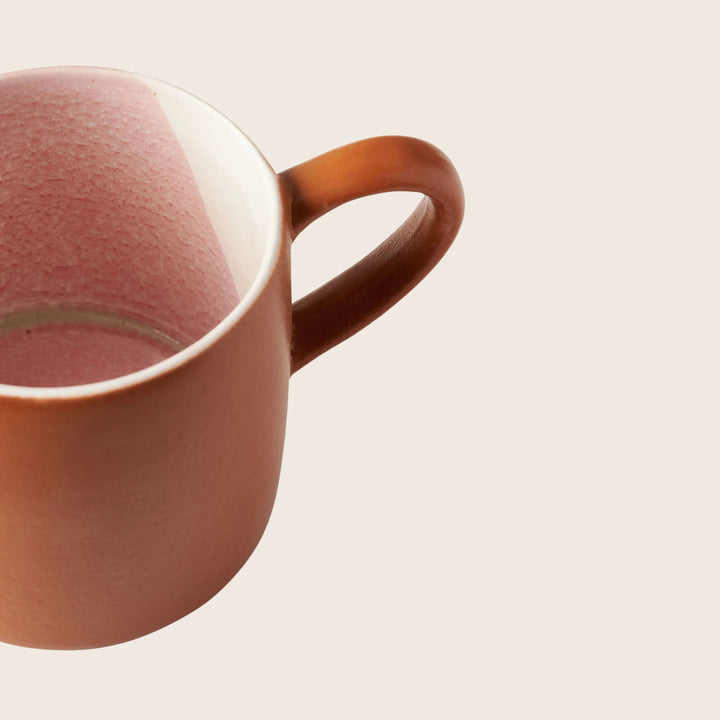 Close-up of ceramic mug with two-tone design on white background.