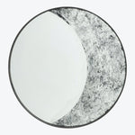Circular plate with white and textured gray/black design, framed border.