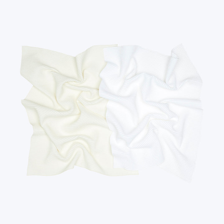 Crumpled white fabric with textured pattern on white background.