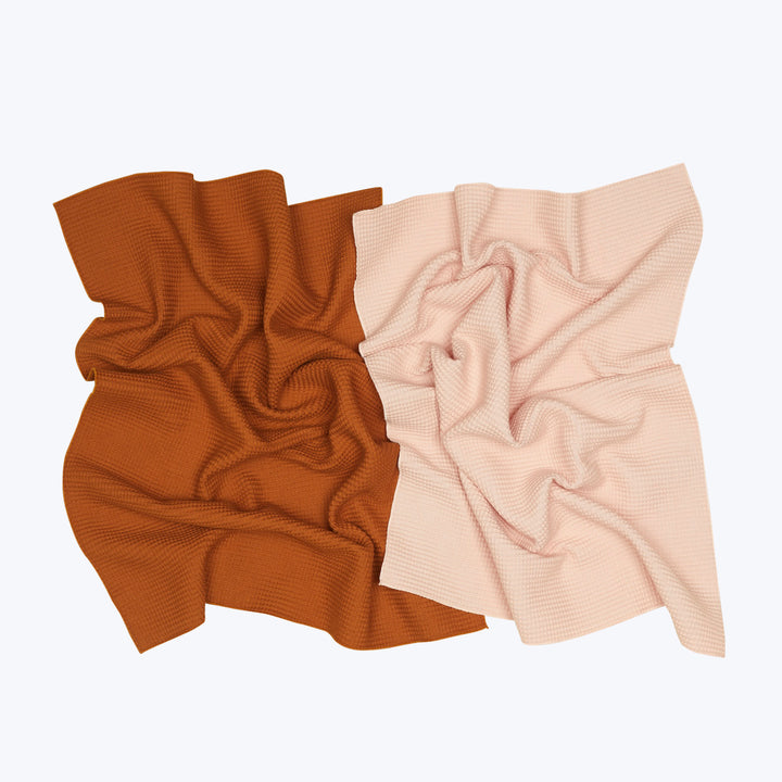 Rich rust and soft pink textured fabrics contrast on white.