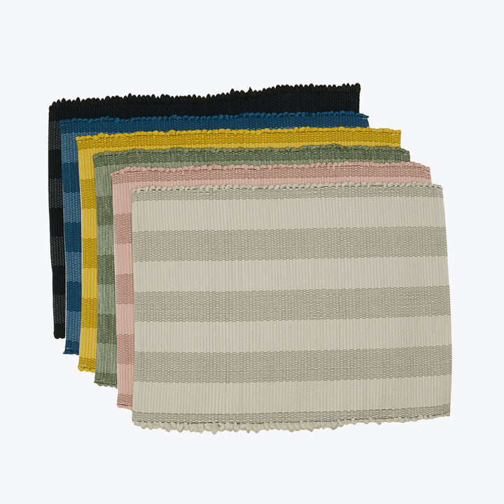 Colorful striped fabric samples stacked with fringed edges, varied textures.