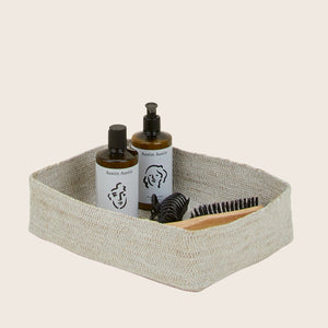 Woven beige basket with square base and raised edges texture. - hover