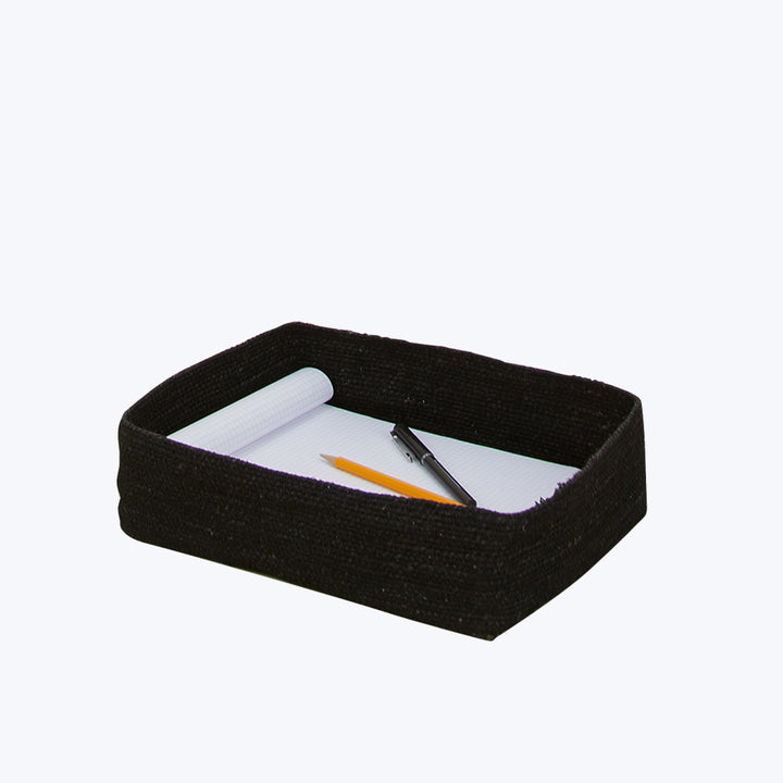 Black rectangular basket with notepad, black pen, and orange highlighter.
