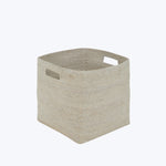 Minimalistic square storage basket in natural beige with cut-out handles.