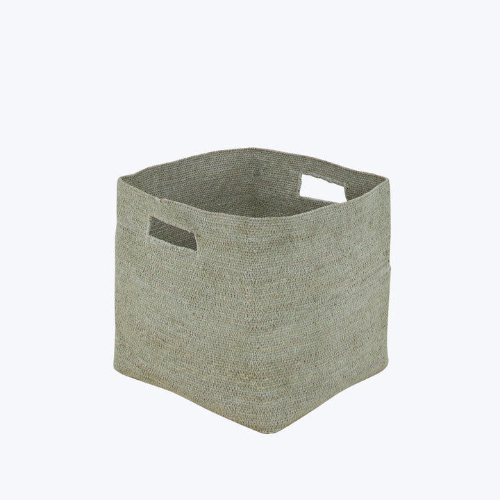 Neutral-colored square fabric storage bin with cut-out handles for carrying.