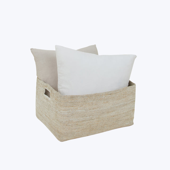 Two pillows in natural fiber basket, perfect home decor solution.