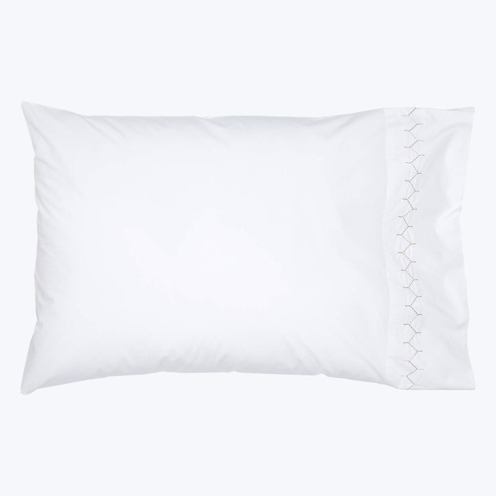 Soft white rectangular pillow with exposed seam stitching on edge.