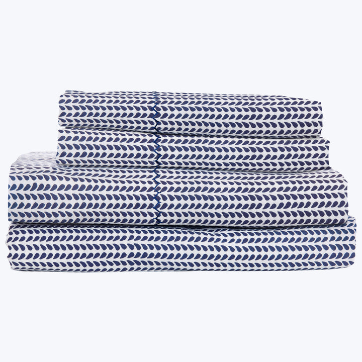 Three stacked blue and white fish-patterned textiles neatly folded.