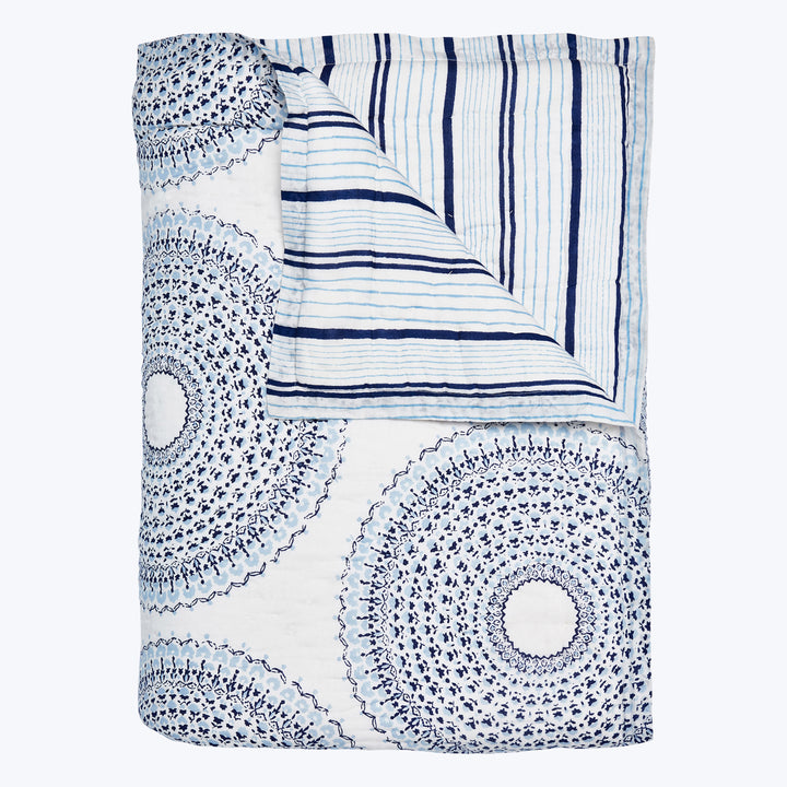Intricate blue and white mandala blanket with stripe design.