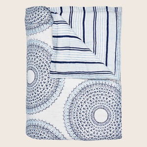 Intricate blue and white mandala blanket with stripe design.