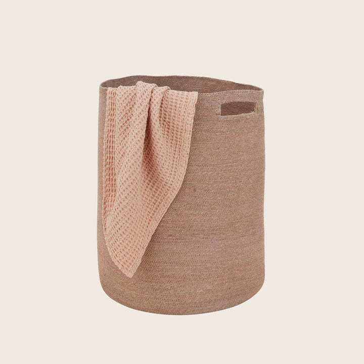 Beige woven fabric storage basket with pink cloth overlay handle.