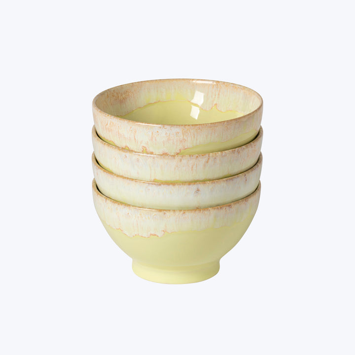 Set of four handmade pastel yellow ceramic bowls on white background.