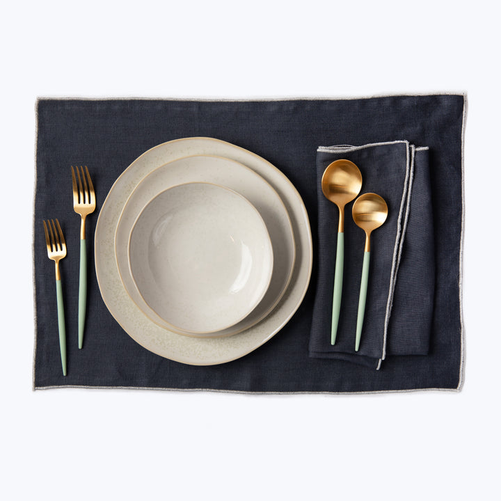 Elegant table setting with modern rustic plates and teal accents.