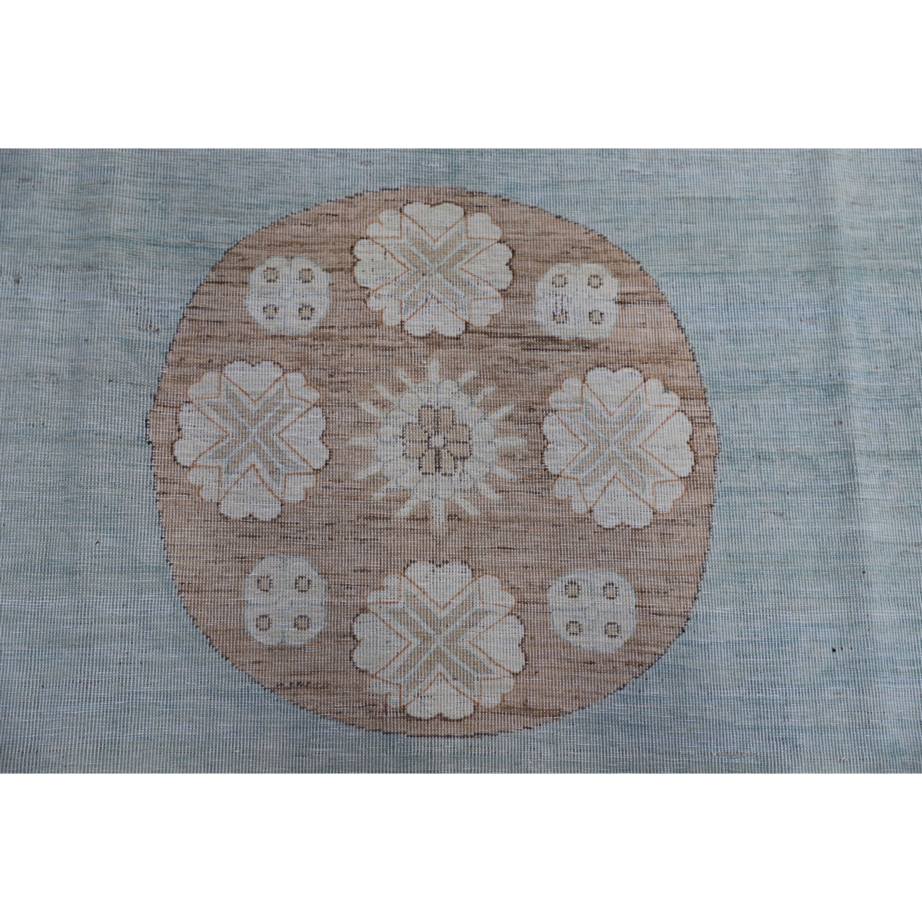 Traditional beige and white embroidered fabric with floral and geometric motifs.