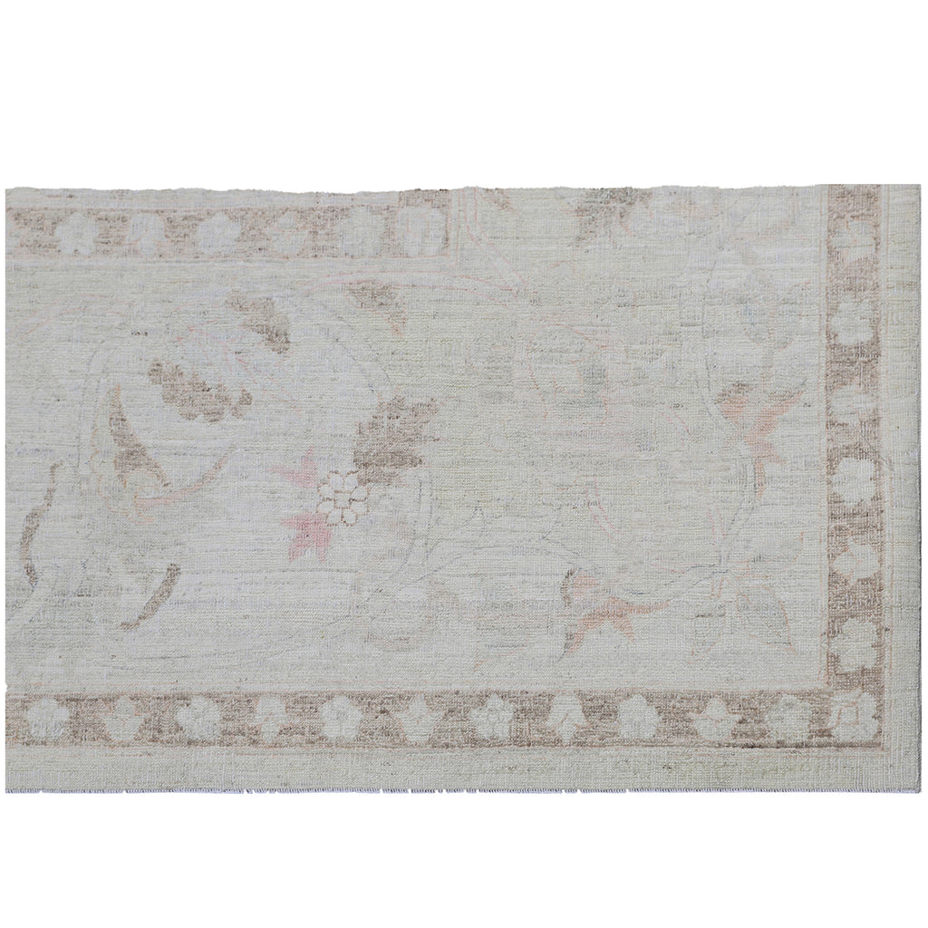 Vintage floral rug with faded pastel hues and geometric border.