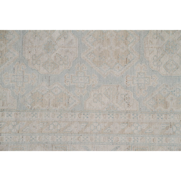 Vintage style wool blend rug with subtle geometric and floral motifs.