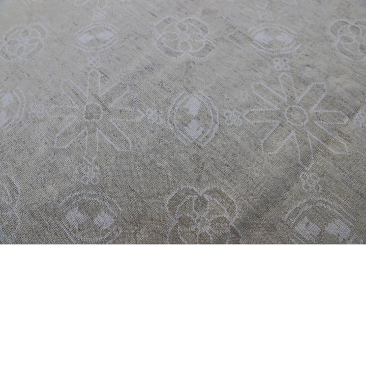 Close-up of elegant fabric with subtle symmetrical floral-like patterns.