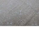 Close-up of elegant fabric with subtle symmetrical floral-like patterns.