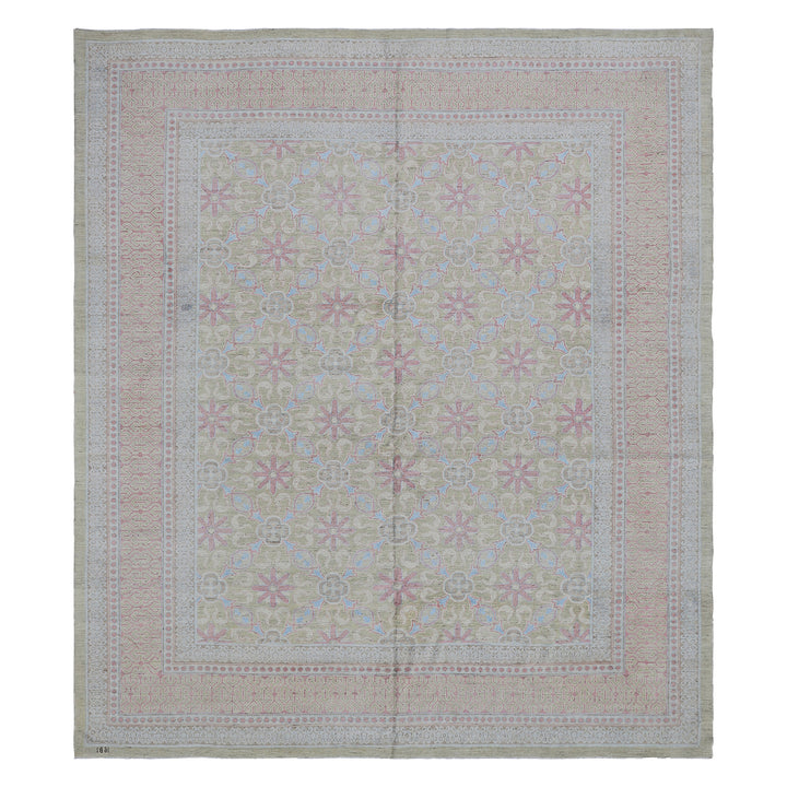 Intricate vintage rug with symmetrical floral pattern in soft colors.
