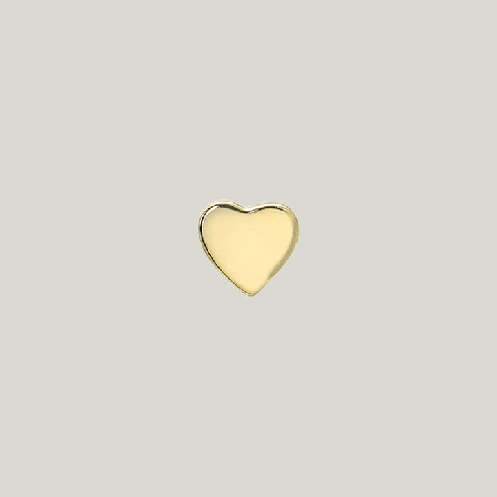 A heart-shaped object with gold finish against light background.