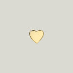 A heart-shaped object with gold finish against light background.