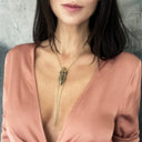 Close-up portrait of woman with rose lips and wing pendant necklace