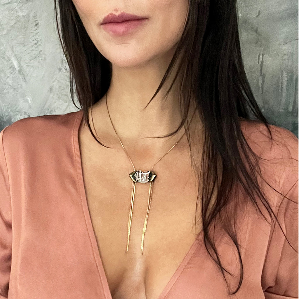 Close-up of woman in pink blouse with unique gemstone necklace