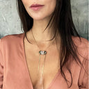 Close-up of woman in pink blouse with unique gemstone necklace