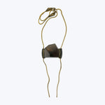 Simplistic necklace with dark gemstone pendant on gold chain.