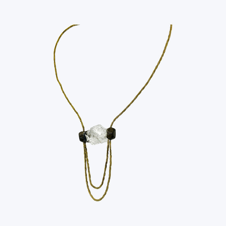Elegant necklace with raw-cut crystal centerpiece and geometric accent stones.