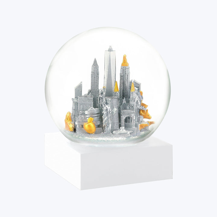 Snow globe with stylized urban skyline, gold and silver accents.
